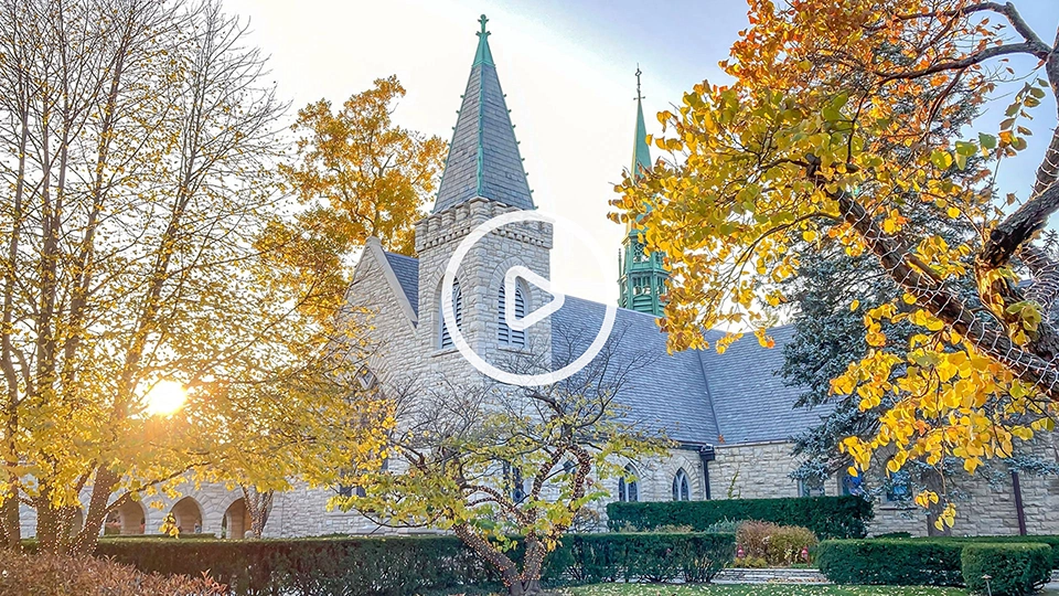 Kenilworth Union Church in the fall with video play button.